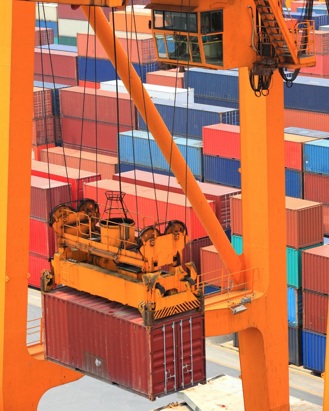 Pórtico movimentando um contêiner no pátio de um porto seco